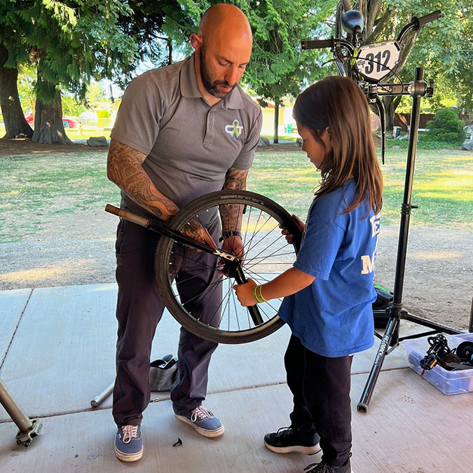 Azus shares bike maintenance with a rider. Azus shares bike maintenance with a rider.