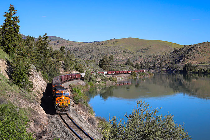 A Tier 4 locomotive leads a grain train eastbound along the Flathead River A Tier 4 locomotive leads a grain train eastbound along the Flathead River