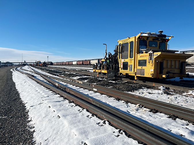 The spike-driving machine pounds the spikes into position. The spike-driving machine pounds the spikes into position.