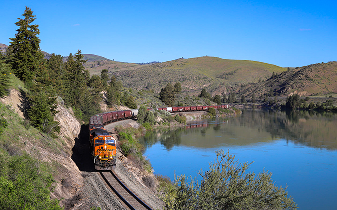 A Tier 4 locomotive leads a grain train eastbound along the Flathead River. A Tier 4 locomotive leads a grain train eastbound along the Flathead River.